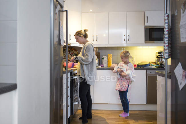 Mãe preparando panqueca na cozinha — Fotografia de Stock