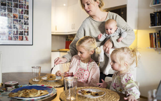 Mother applying jam for daughters — Stock Photo