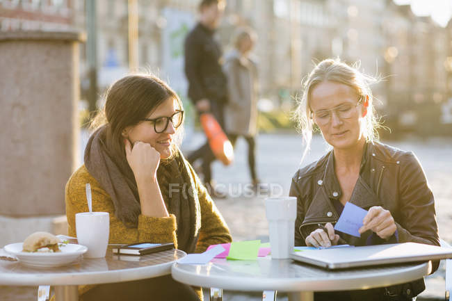 Businesswoman writing notes with colleague — Stock Photo