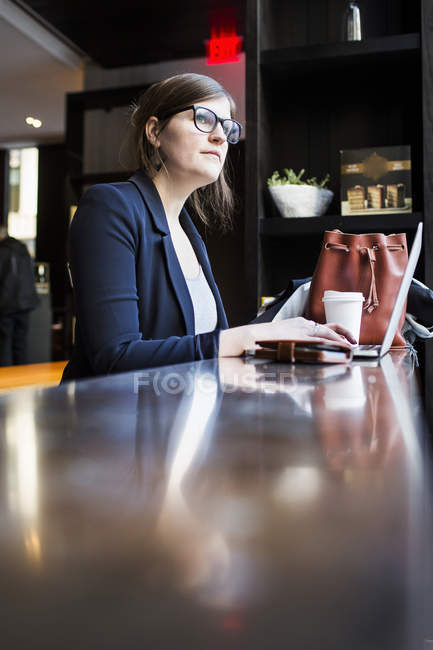 Businesswoman using laptop at table — Stock Photo