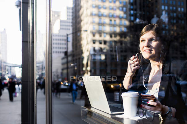 Бізнес-леді з навушниками за допомогою ноутбука — стокове фото