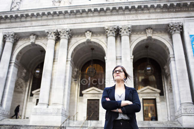 Femme d'affaires debout contre la bibliothèque publique de New York — Photo de stock