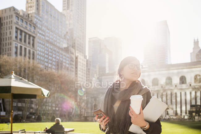 Businesswoman holding smartphone and laptop — Stock Photo