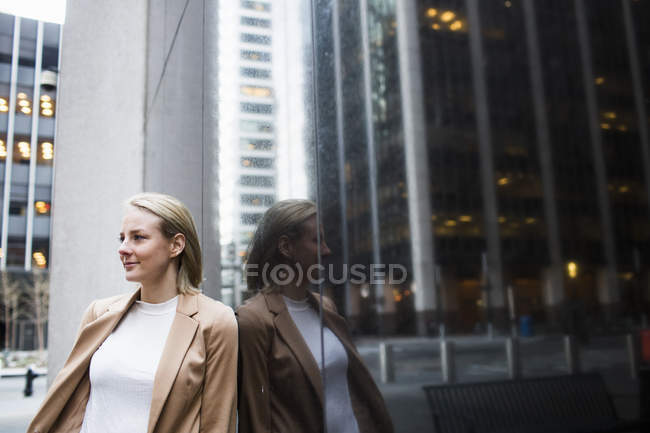 Бізнес-леді стоїть біля скляного вікна — стокове фото