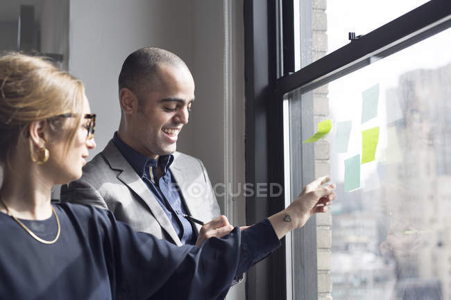 Businesswoman explaining about sticky notes — Stock Photo