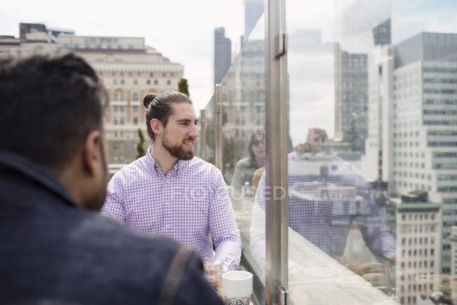 Мужчины сидят в ресторане на крыше — стоковое фото