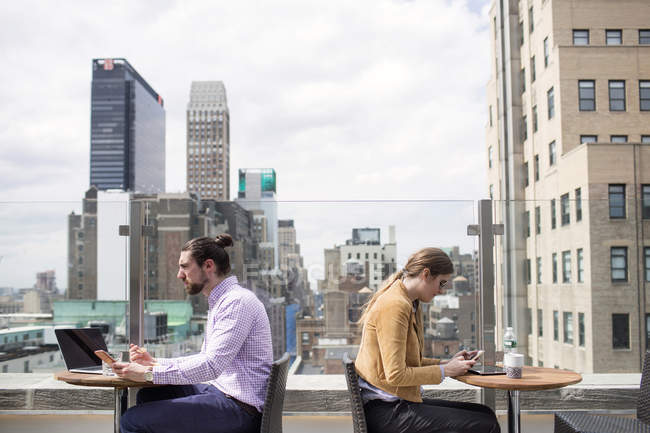 Business people working while sitting at rooftop — Stock Photo