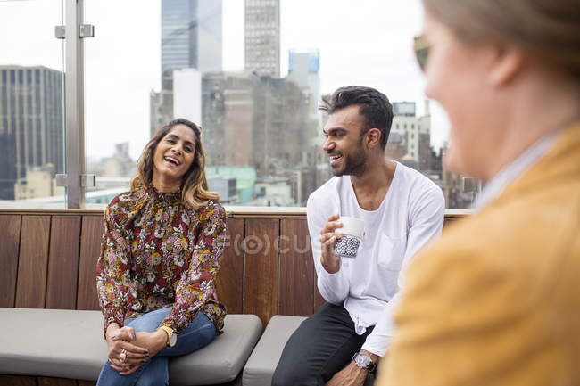 Friends relaxing at rooftop restaurant — Stock Photo