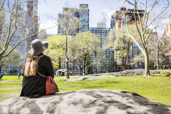 Donna seduta sulla roccia a Central Park — Foto stock