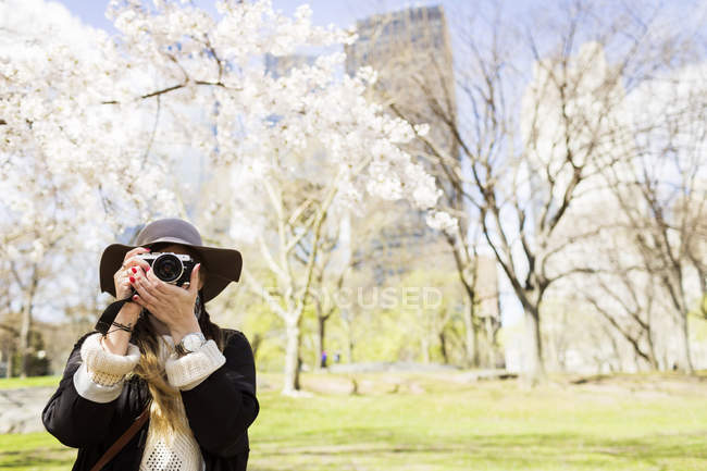 Woman with camera standing at Central Park — Stock Photo