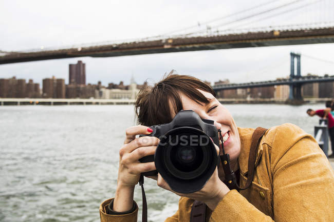 Mulher sorridente com câmera — Fotografia de Stock