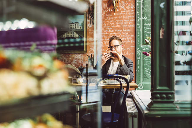 Человек, использующий смартфон в кафе — стоковое фото