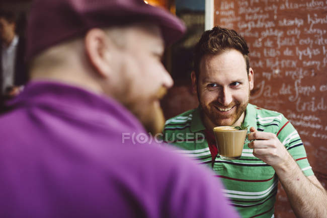 Двое мужчин пьют кофе в кафе — стоковое фото