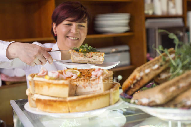 Femme souriante servant tarte — Photo de stock