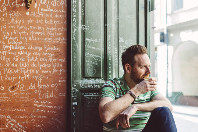 Hombre sosteniendo taza de café en la cafetería - foto de stock