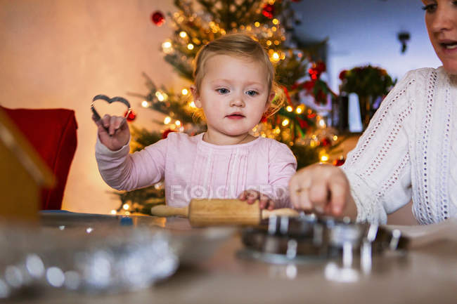 Mãe e menina com cortadores de biscoitos — Fotografia de Stock
