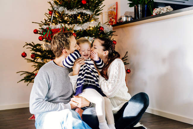 Родители целуют дочь — стоковое фото