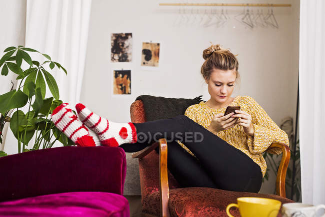 Женщина с телефоном во время отдыха на стуле — стоковое фото