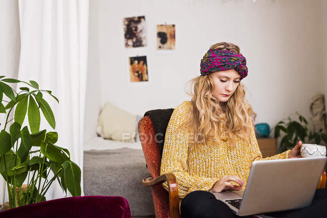 Femme utilisant un ordinateur portable à la maison — Photo de stock