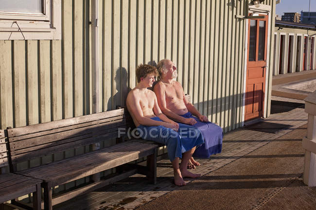 Отец и сын отдыхают на скамейке — стоковое фото