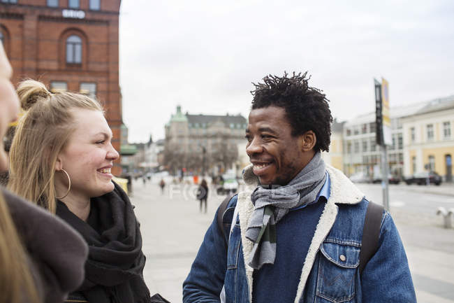 Friends talking while standing in city — Stock Photo