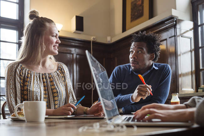 Amigos conversando ao usar laptop — Fotografia de Stock