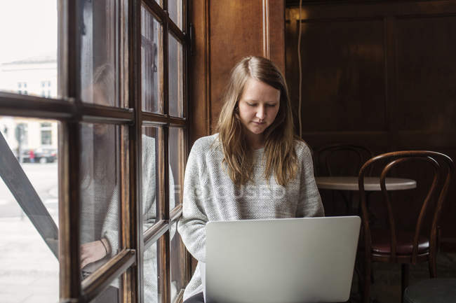 Продумана жінка використовує ноутбук — стокове фото