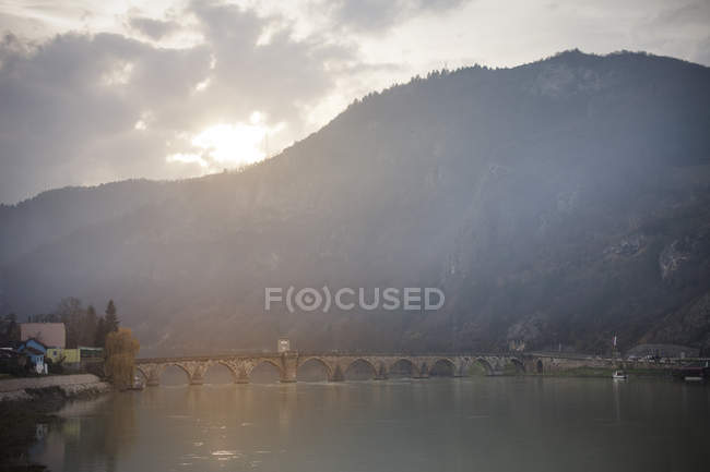 Міст над річкою проти гори — стокове фото