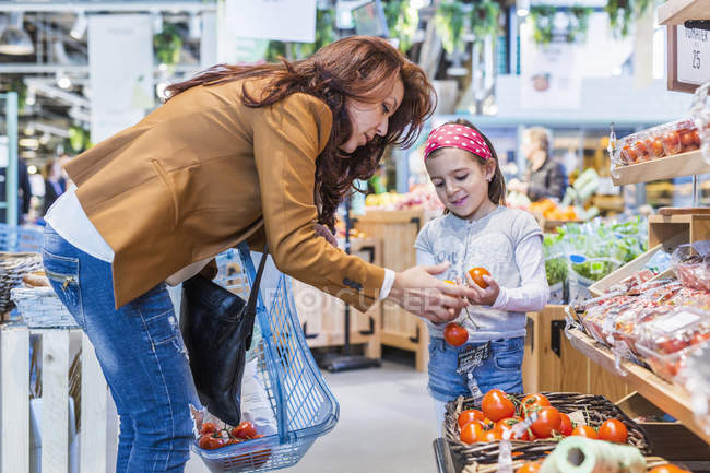 Mãe e filha comprando tomates — Fotografia de Stock