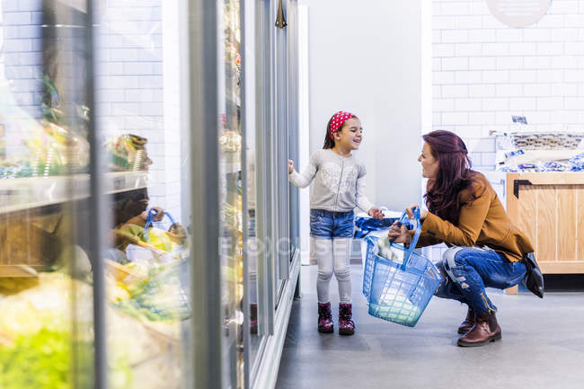 Feliz madre e hija en el supermercado - foto de stock