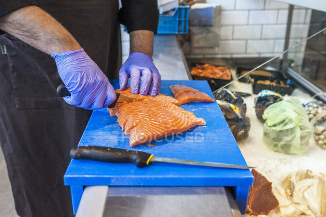 Vendor cutting salmon — Stock Photo