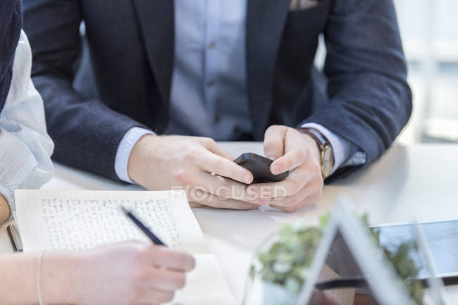 Businessman using phone in meeting — Stock Photo