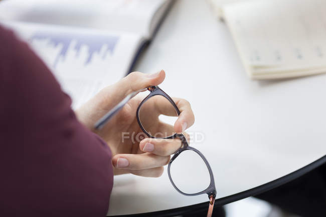 Бізнесмен тримає окуляри за столом — стокове фото