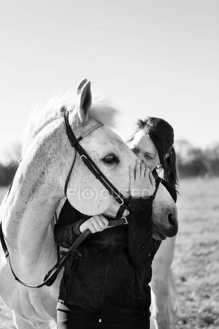 Женщина целует лошадь — стоковое фото
