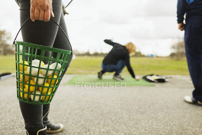 Woman holding basket with balls — Stock Photo