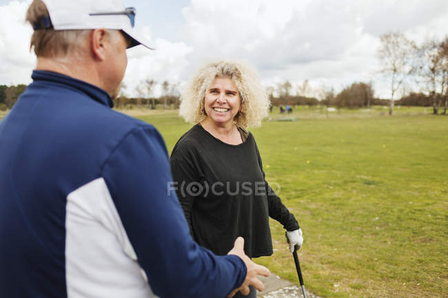 Друзья разговаривают во время игры в гольф — стоковое фото