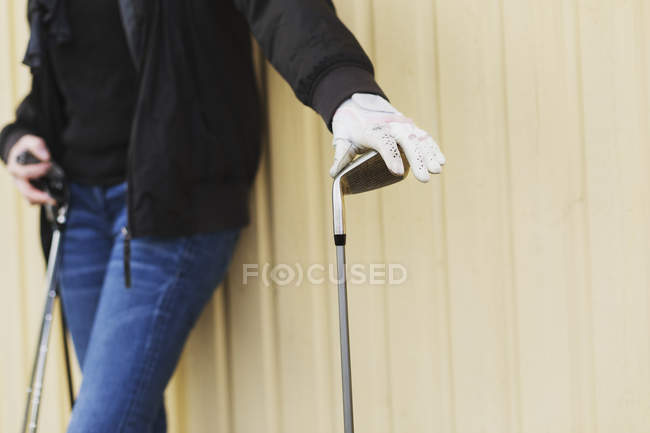 Женщина держит клюшки для гольфа — стоковое фото