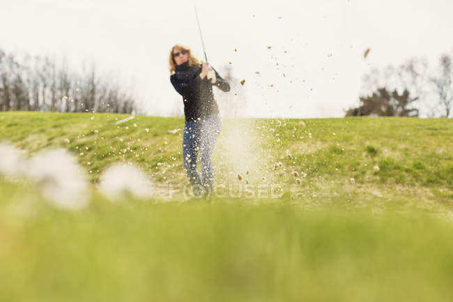 Mujer jugando al golf en el campo de golf - foto de stock