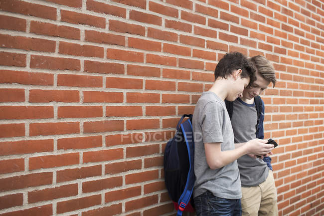 Écoliers utilisant le téléphone mobile — Photo de stock