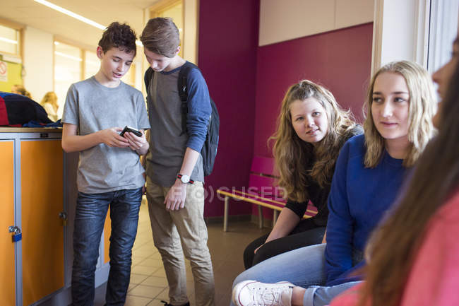 Crianças em idade escolar a falar no corredor — Fotografia de Stock
