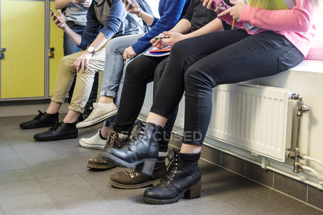Écoliers assis dans le couloir — Photo de stock