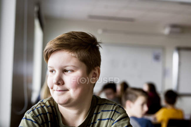 Portrait of schoolboy in classroom — Stock Photo