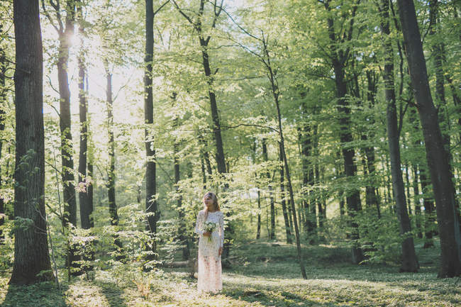 Наречена тримає букет в лісі — стокове фото