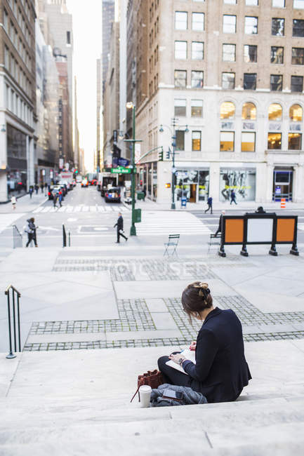 Businesswoman sitting on steps — Stock Photo