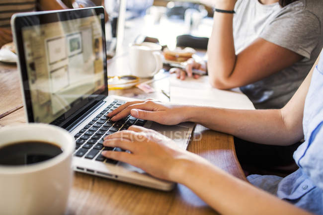 Фрилансеры, работающие на ноутбуке в кафе — стоковое фото