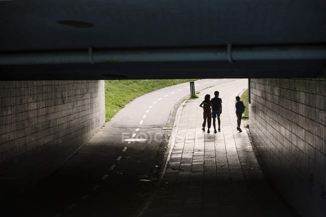 Children walking at dark tunnel — Stock Photo