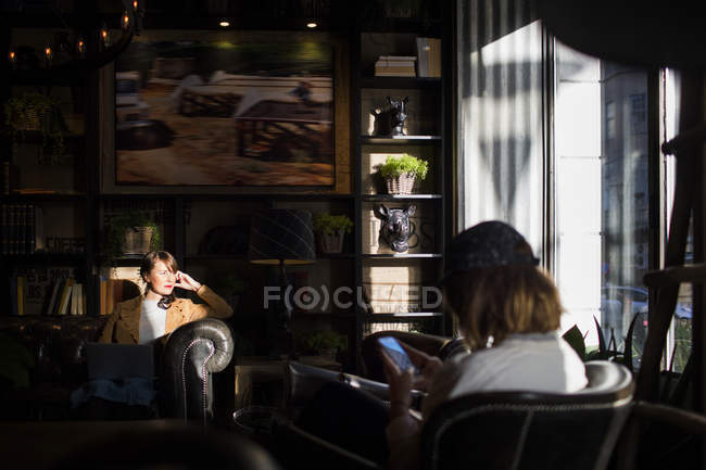 Mujeres sentadas en una cafetería - foto de stock