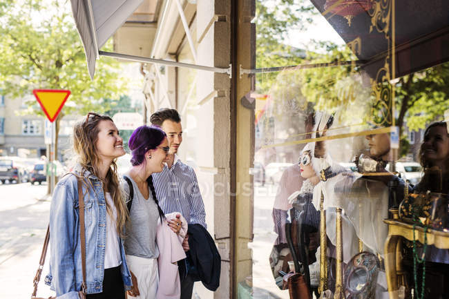 Друзья смотрят в витрину магазина — стоковое фото