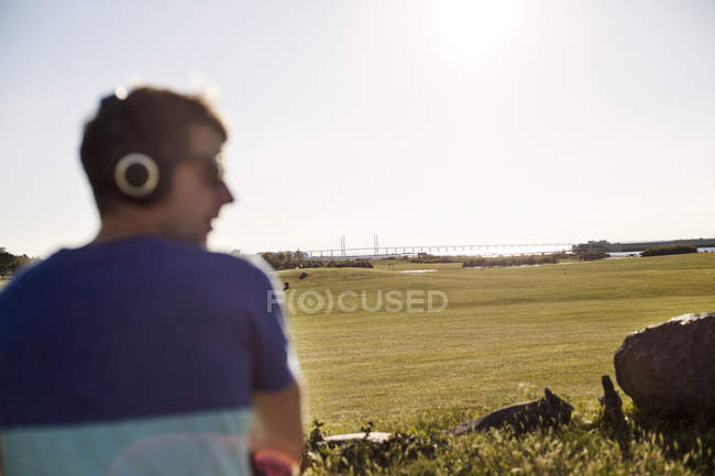 Людина слухає музику в парку — стокове фото