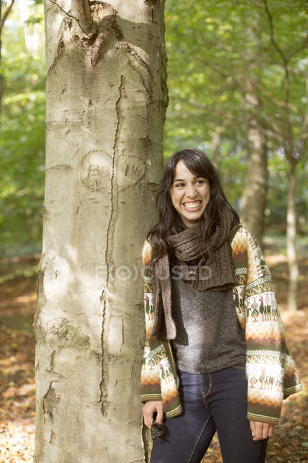 Frau lehnt im Wald an Baum — Stockfoto